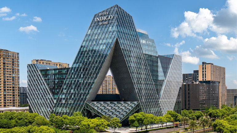 Exterior of Hotel Indigo Ningbo, featuring a striking geometric glass facade in an urban setting.