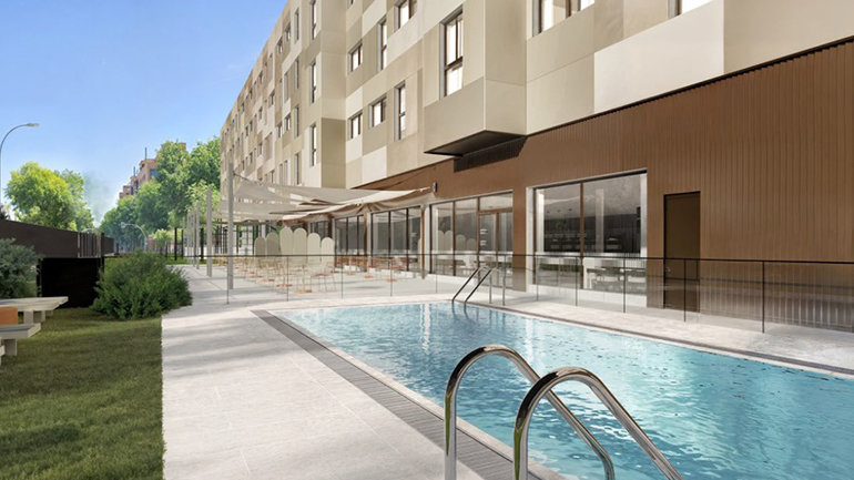 Design rendering of the outdoor pool and terrace at Holiday Inn Express Madrid – Julián Camarillo, depicting a rectangular swimming pool, sun terrace with seating, landscaped greenery, and the hotel building façade in the background.