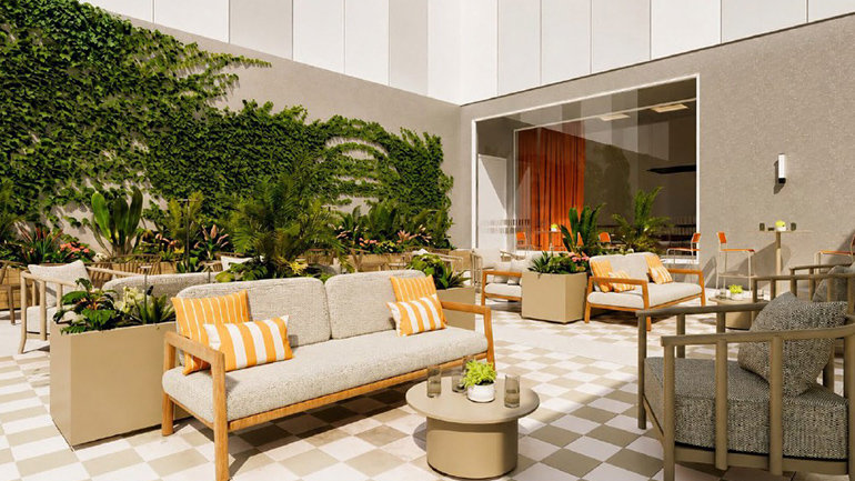Design rendering of the outdoor courtyard at Holiday Inn Express & Suites Málaga – Palacio de Congresos, showcasing a bright seating area with sofas, planters, greenery walls, and a tiled floor designed for guest relaxation.