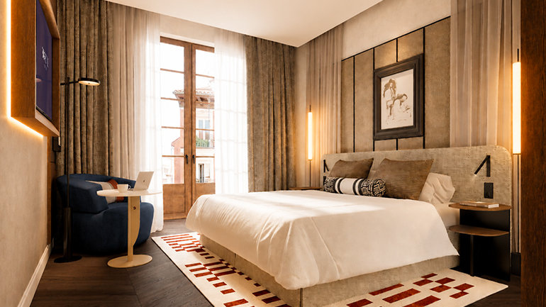 Modern hotel guestroom with a king-size bed, textured headboard and warm neutral colour palette. Floor-to-ceiling windows bring in natural light, while bespoke furnishings, soft lighting, dark wood flooring and geometric detailing create a refined and inviting atmosphere inspired by contemporary Italian design. 