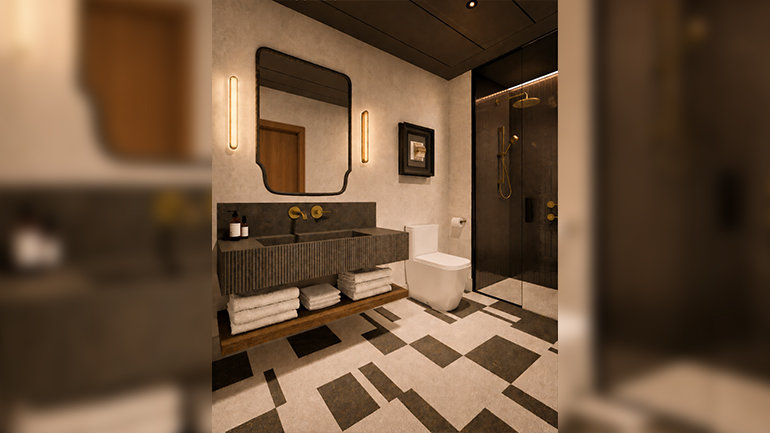 Contemporary hotel bathroom featuring a floating dark stone vanity with integrated sink, brass wall-mounted fixtures and a large decorative mirror. The space includes a walk-in glass shower with bronze detailing, geometric patterned floor tiles, warm ambient lighting and natural wood accents, creating a sophisticated residential feel. 