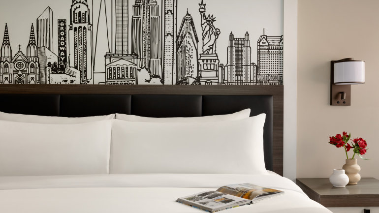 King guestroom with modern design and NYC-inspired artwork at Crowne Plaza Manhattan Times Square by IHG